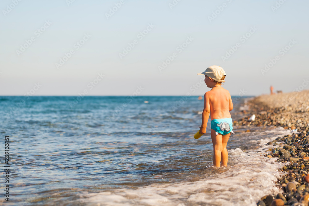 Boy child playing in pebble beach sea coast resort Batumi