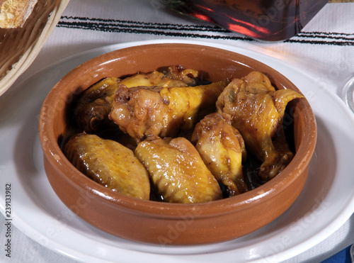 Cazuela con muslitos de pollo asados picantes adobados con ajo y guindilla