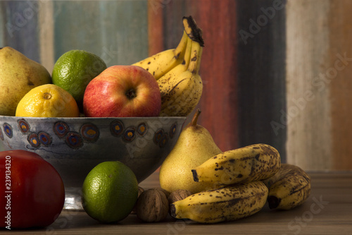 Bowl of different fruits on a colorful background