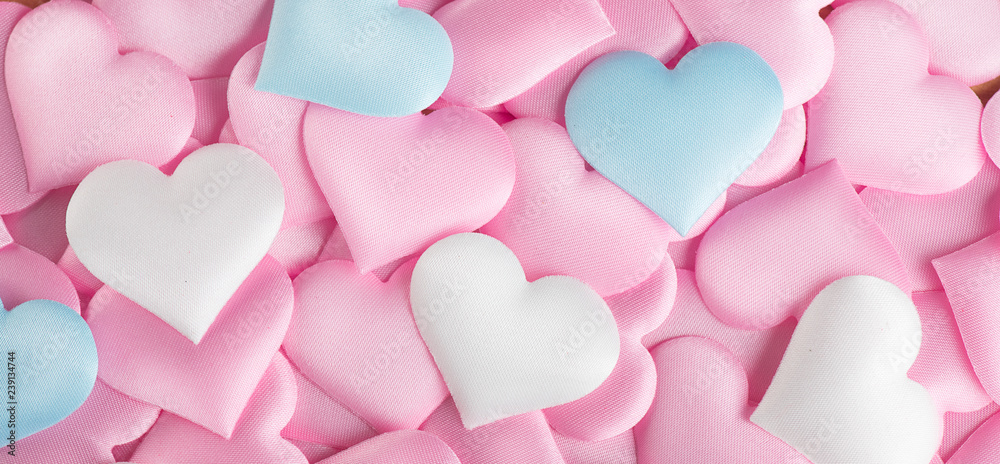 Valentine's Day. Pink heart shape backdrop. Abstract holiday Valentine background with pink, white and blue pastel color satin hearts. Love concept. Flat lay, top view 