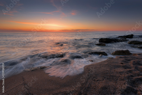 Seascape during sunrise. Beautiful natural seascape, blue hour. Sea sunrise at a Black coast near Varna, Bulgaria. Magnificent sunrise with clouds in the middle of April.