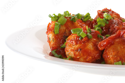 Meatballs in tomato sauce served on a plate. Isolated on white background.