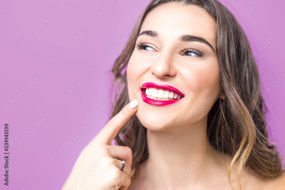 Dentistry concept. Beautiful young woman smiling, showing healthy white teeth, red lipstick. Close-up of a girl on a pink background. Dentistry concept. Beautiful young woman smiling, showing healthy white teeth, red lipstick. Close-up of a girl on a pink background.