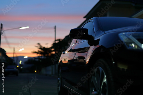 luxury vehicle black car with blur twilight dramatic sky, image selective focus on side mirror © sutichak