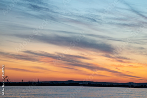 Beautiful sunset on the river. Summer sunset or sunrise landscape with golden light in Yakutia  Republic of Sakha  Russia. Riverscape taken from a ferry on river Lena