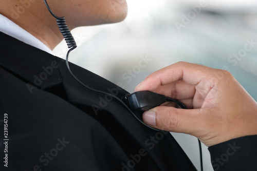 Male security guard using portable radio outdoors photo