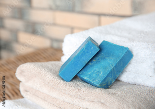 Blue handmade soap bars on clean towels. Space for text