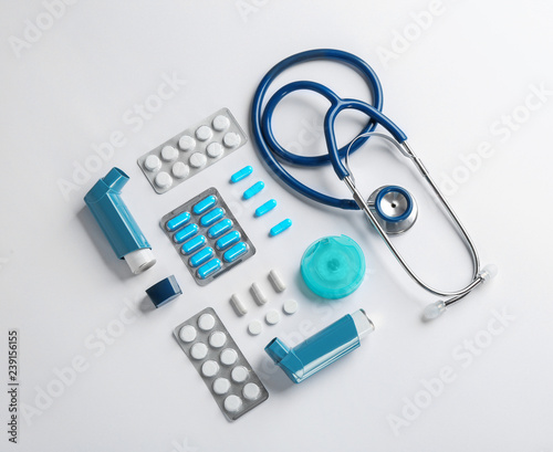 Flat lay composition with stethoscope and asthma medications on white background photo