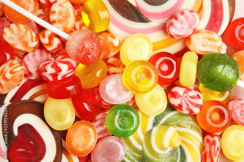 Different delicious colorful candies as background, top view