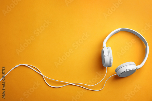 Stylish headphones on color background, top view. Space for text photo