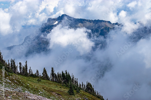 majestic view of moutain peaks through clouds and fog