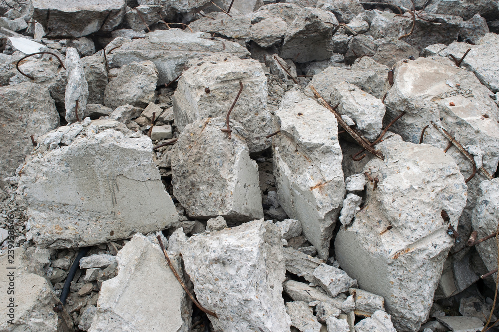 Fragments of concrete slabs in the form of large gray stones with protruding reinforcement. Background