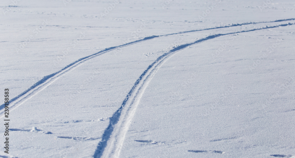 Traces of cars on white snow as a background