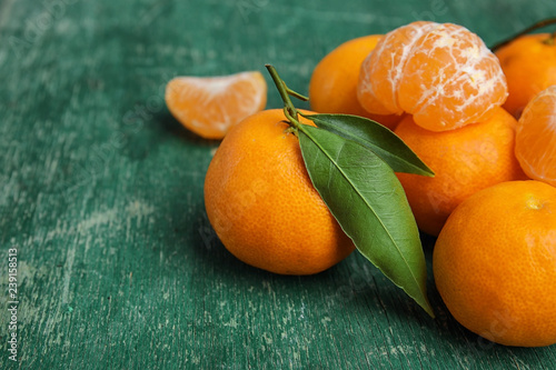 Fresh ripe tangerines with green leaves on table