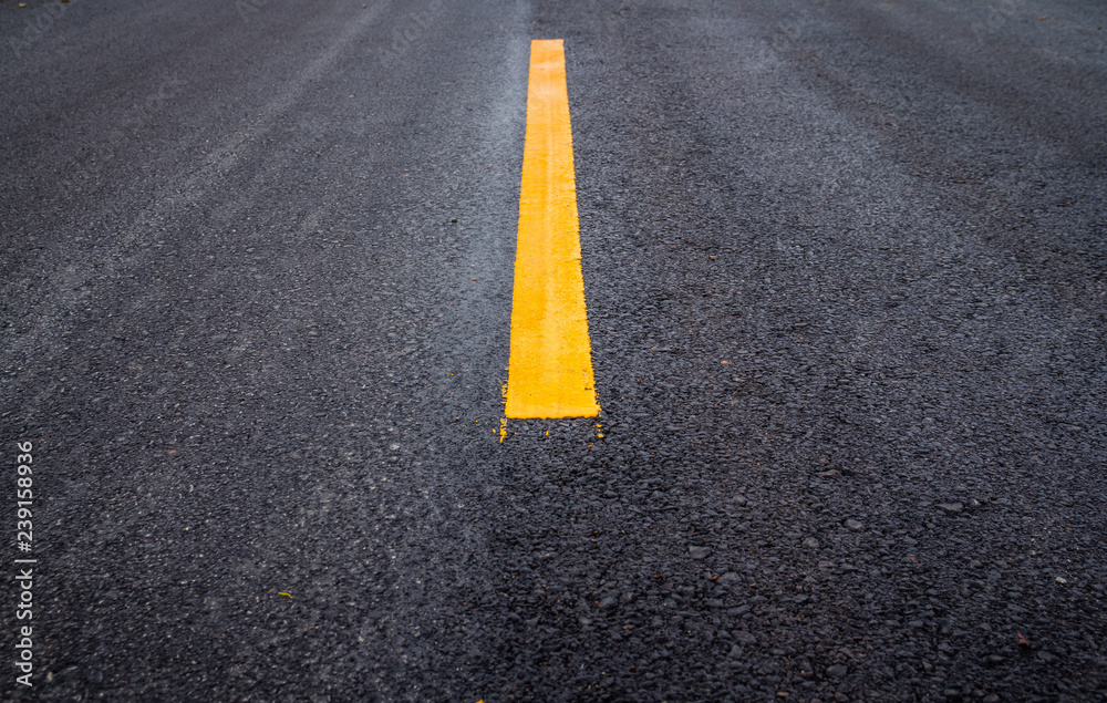 Asphalt road surface with yellow line