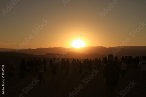 Silhouette of a lot of people watching the incredible sunset at Valle de la Luna or Moon Valley in Atacama Desert, San Pedro Atacama, Northern Chile