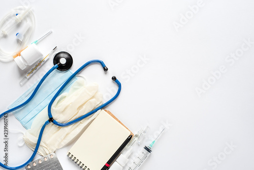 Various medical equipment and Notepad on white background. The view from the top.