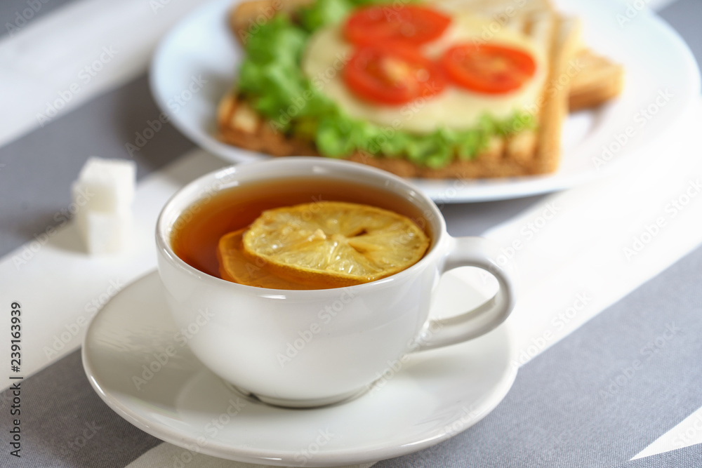 Fresh, tasty breakfast with a sandwich and tea on a light background. Fresh, tasty breakfast with a sandwich and tea on a light background.