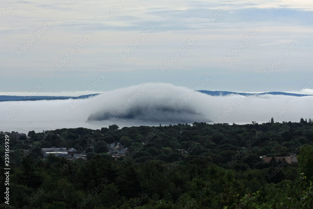 Dense fog rolling into Bar Harbor, Maine, covering islands in the distance in Frenchman Bay.