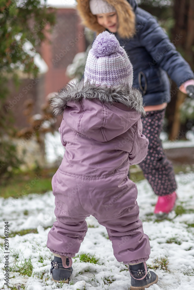 Two little girls playing on the snow