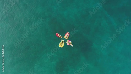 Aerial view group of women holding hands on inflatable mattress on Atokos. photo