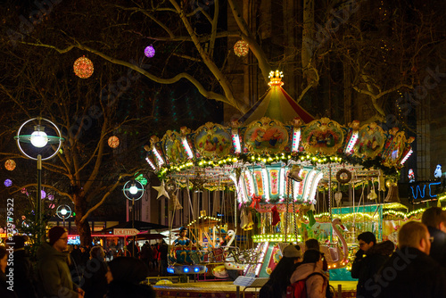 Night outdoor colorful  illuminated carousel and crowded on the street of Christmas market in Dortmund, Germany.   © Peeradontax