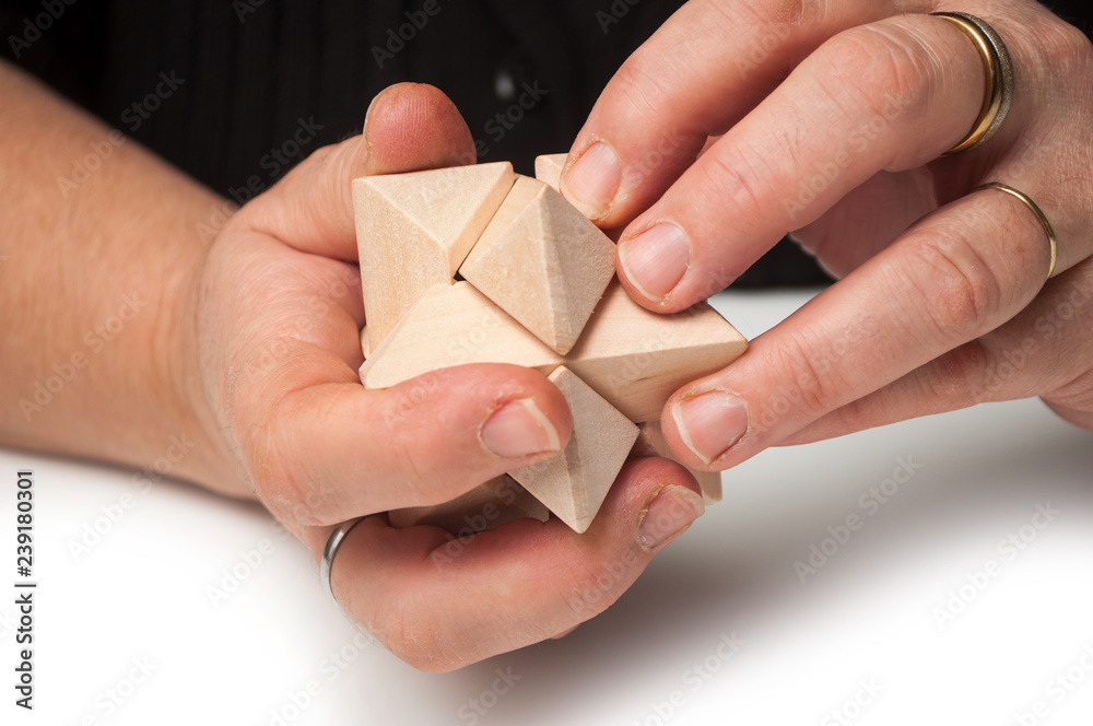 Fototapeta premium closeup of woman hand with wooden puzzle on white table background