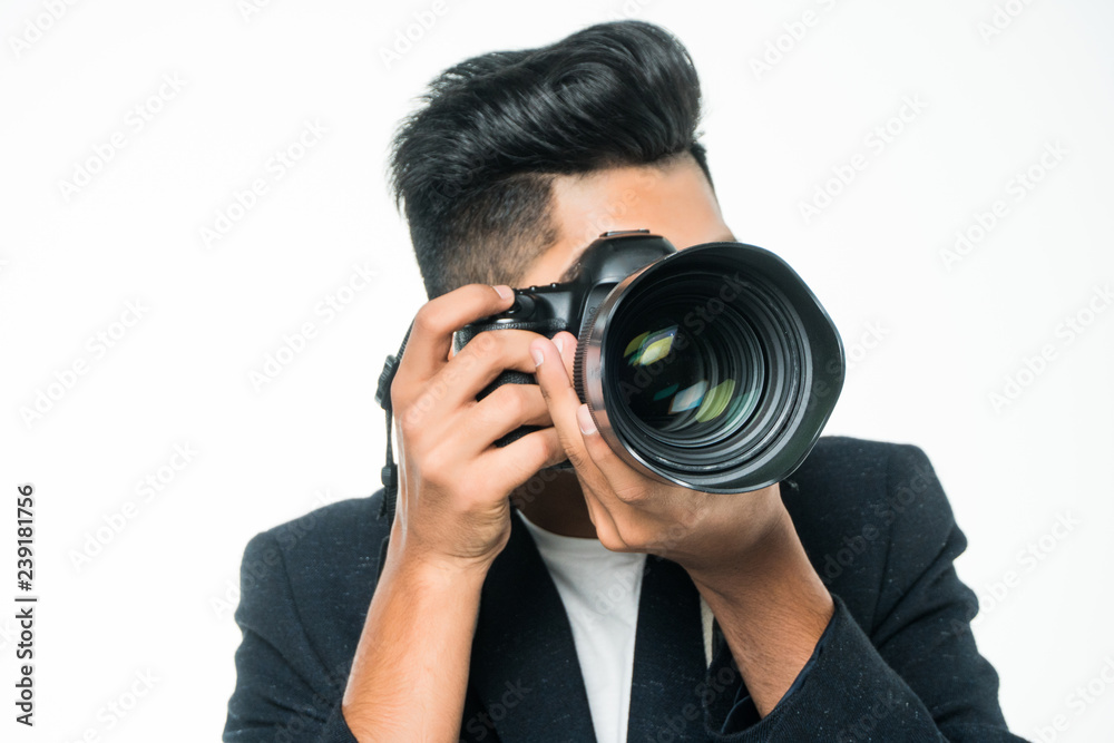 Young indian man with camera isolated over white background. Young indian man with camera isolated over white background.