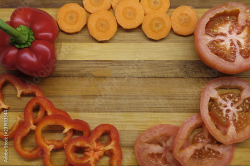 Sliced tomato, pepper and carrot on the table close-up photo