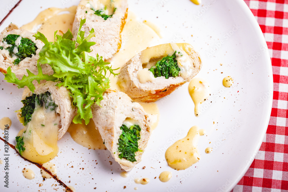 Steamed chicken cutlets stuffed with spinach on white plate. Top view. Close up Steamed chicken cutlets stuffed with spinach on white plate. Top view. Close up