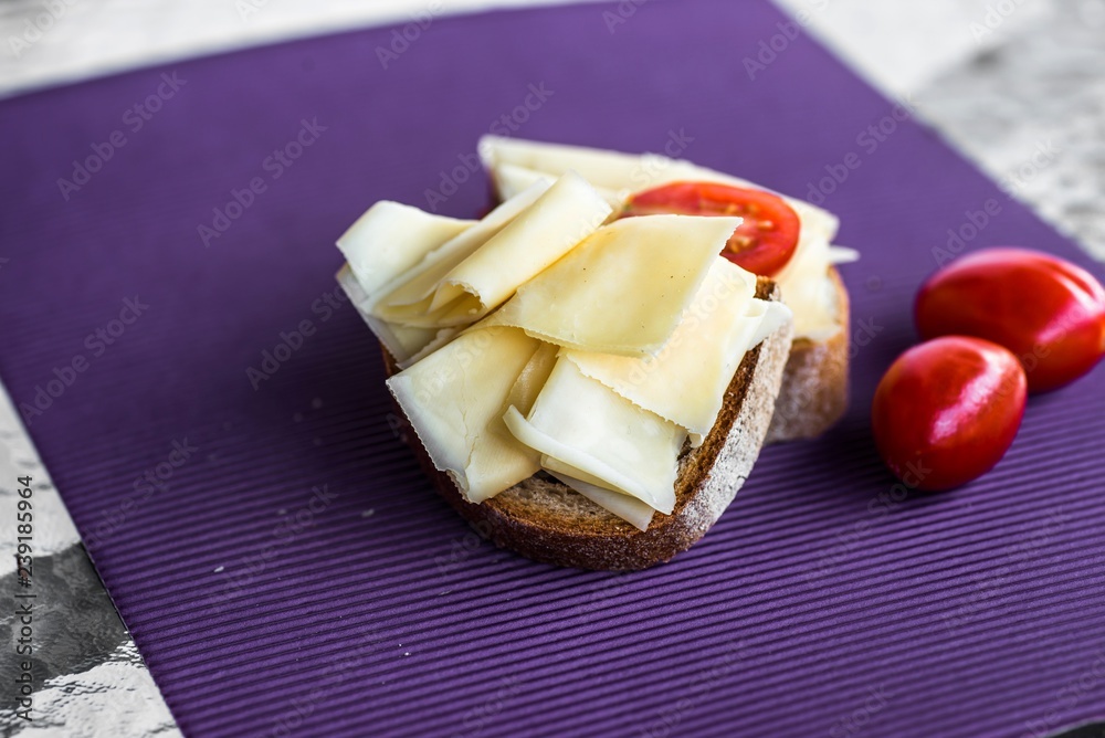 Fototapeta Bread with cheese and tomato on table.