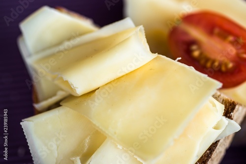 Sliced emmental cheese and halved cherry tomato.
