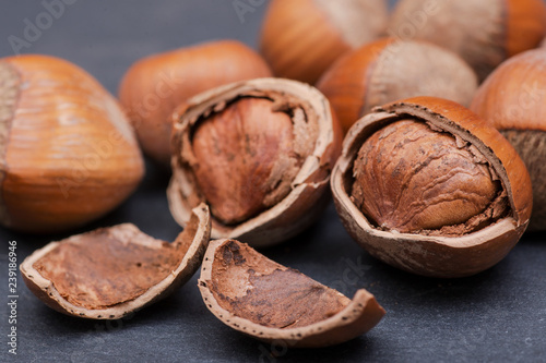 Fresh organic high quality hazelnuts, filberts in wooden bowl on natural stone background.