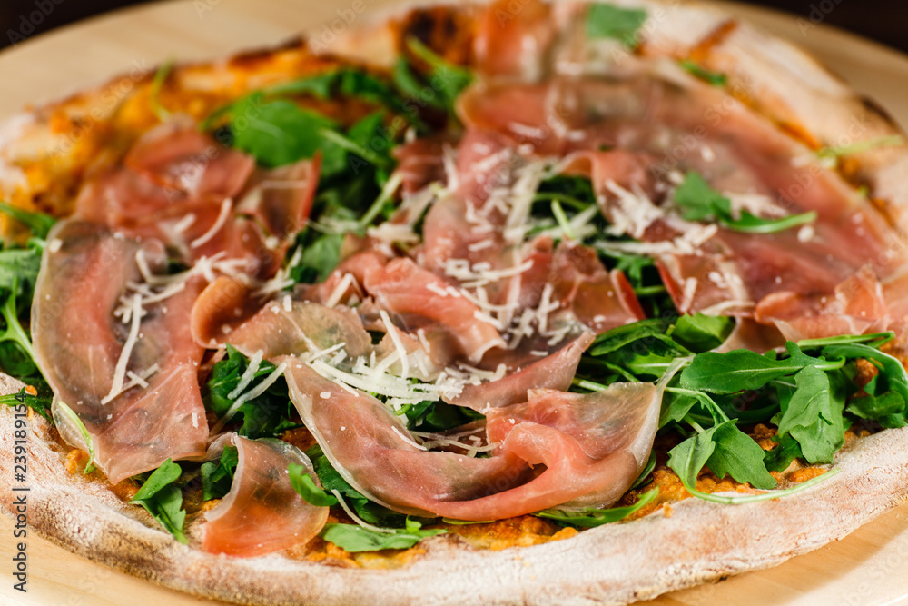 Pizza with ham and vegetables on wooden table