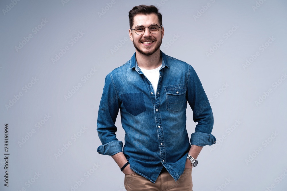 Portrait of happy fashionable handsome man in jeans shirt crossing hands and look at camera. Portrait of happy fashionable handsome man in jeans shirt crossing hands and look at camera.