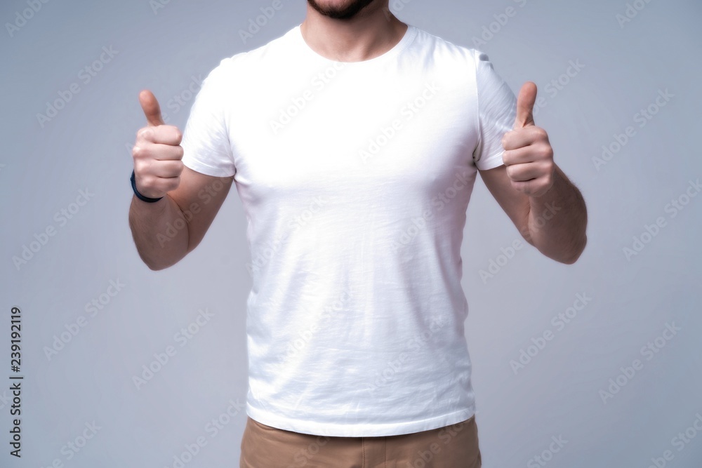 Young man wearing blank white t-shirt isolated on white background. Copy space. Place for advertisement. Front view Young man wearing blank white t-shirt isolated on white background. Copy space. Place for advertisement. Front view