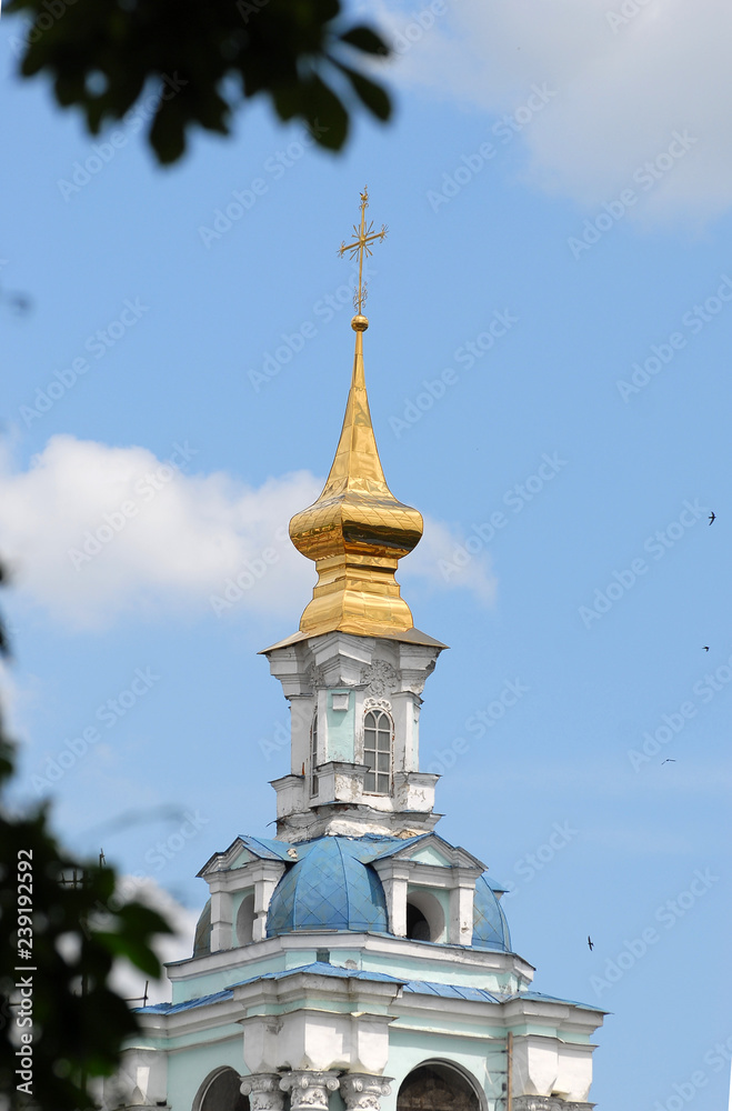 The dome of the temple against the blue sky with clouds