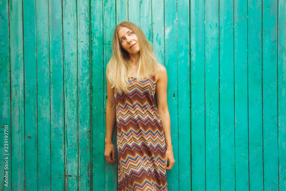 Fototapeta premium Young woman posing on green wooden background