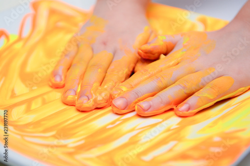 Happy child playing with paint, the girl has paint on hands and fingers