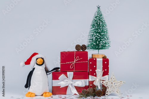Fotografie Yoda with Santa Claus Hat stands near a little Christmas tree on gift packs with