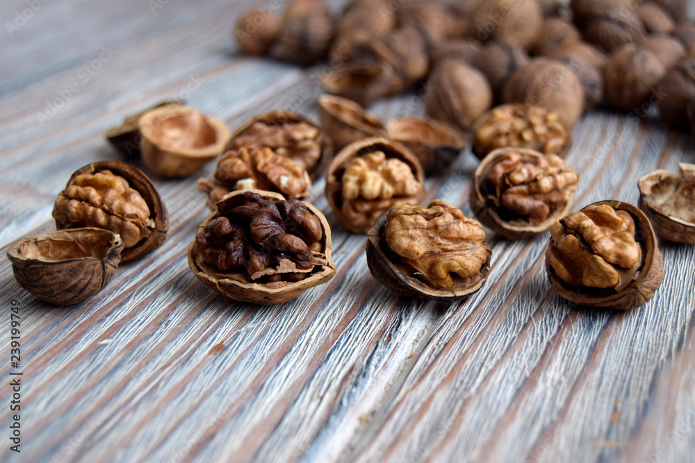 Walnuts are on a wooden surface. Walnuts are shelled. The edible kernel of nut is in a shell. Walnuts are on a wooden surface. Walnuts are shelled. The edible kernel of nut is in a shell.