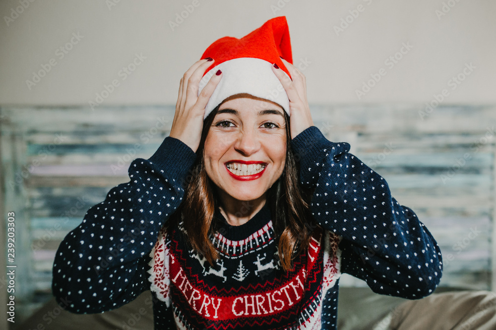 Obraz premium .Sweet and cheerful woman enjoying christmas at her home. Wearing christmas costume, singing, screaming and having fun. Lifestyle. Season photography.