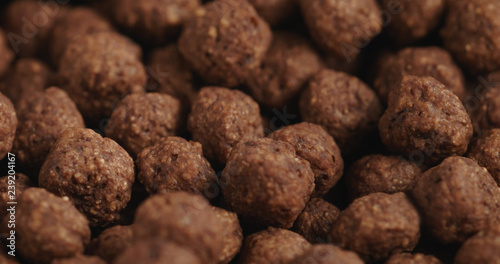Closeup of chocolate cereal balls in white bowl for breakfast on wooden table