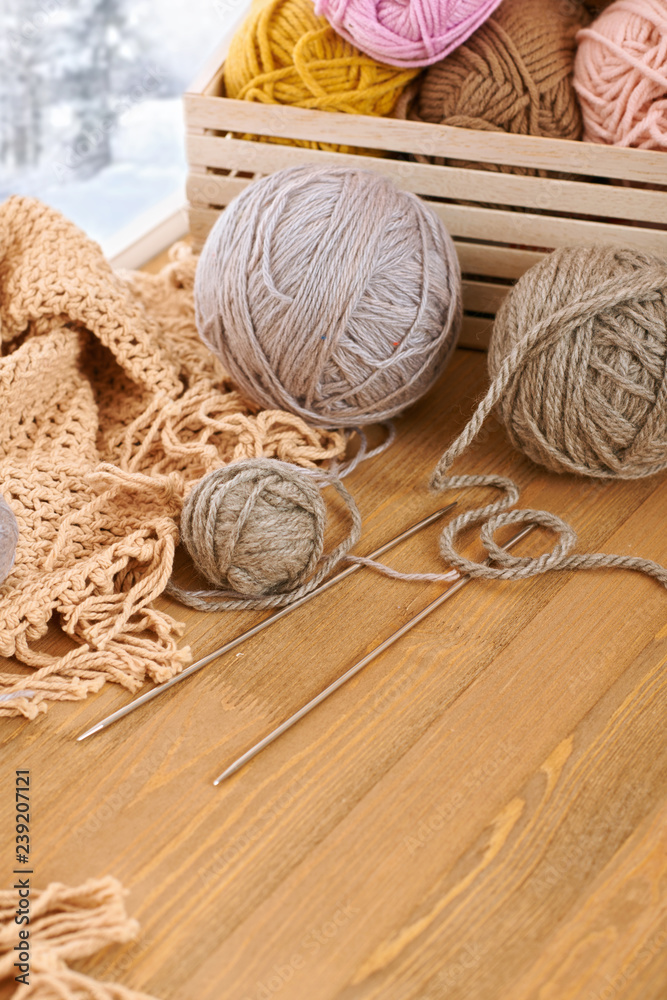 Woolen yarn and fabric on the window sill. Beautiful view outside the window - winter scenery and snow. Woolen yarn and fabric on the window sill. Beautiful view outside the window - winter scenery and snow.
