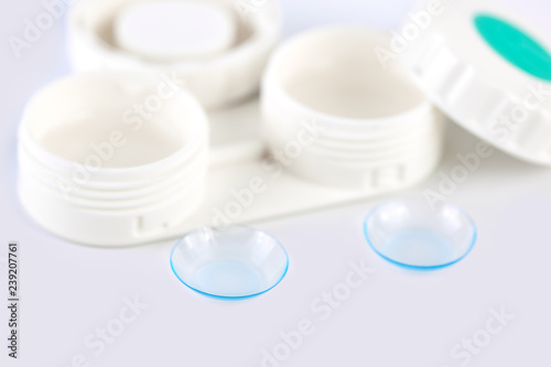 Contact lens, contact lens case, tweezers on white background. Correction of vision.