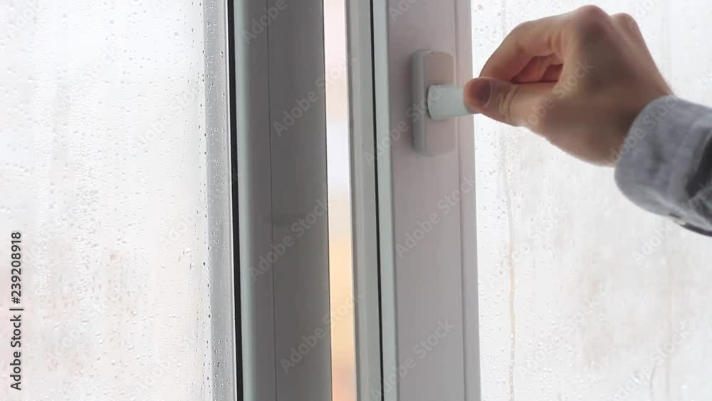 man's hand opens plastic window facing the street man's hand opens plastic window facing the street