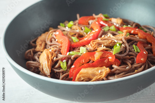Dark pasta with steamed vegetables and grilled chicken. Delicious buckwheat noodles with vegetables and chicken