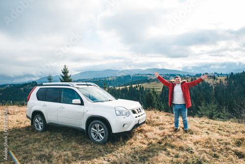 Fototapeta Naklejka Na Ścianę i Meble -  freedom of car travel. car with man at the top of the hill with beautiful view on mountains