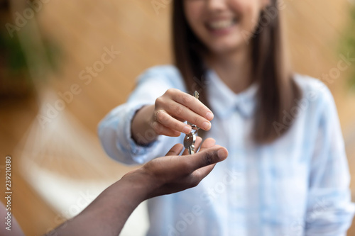Smiling realtor agent giving keys to African American apartment buyer, successful real estate purchase, black client take loan, mortgage, getting access to new home, good negotiation, close up