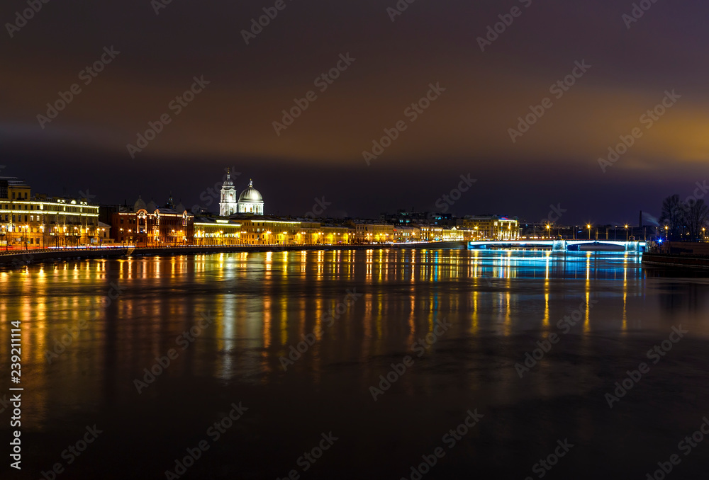 beautiful illumination of the Neva river embankment with ancient Baroque buildings at night with a beautiful sunset glow of pink color.